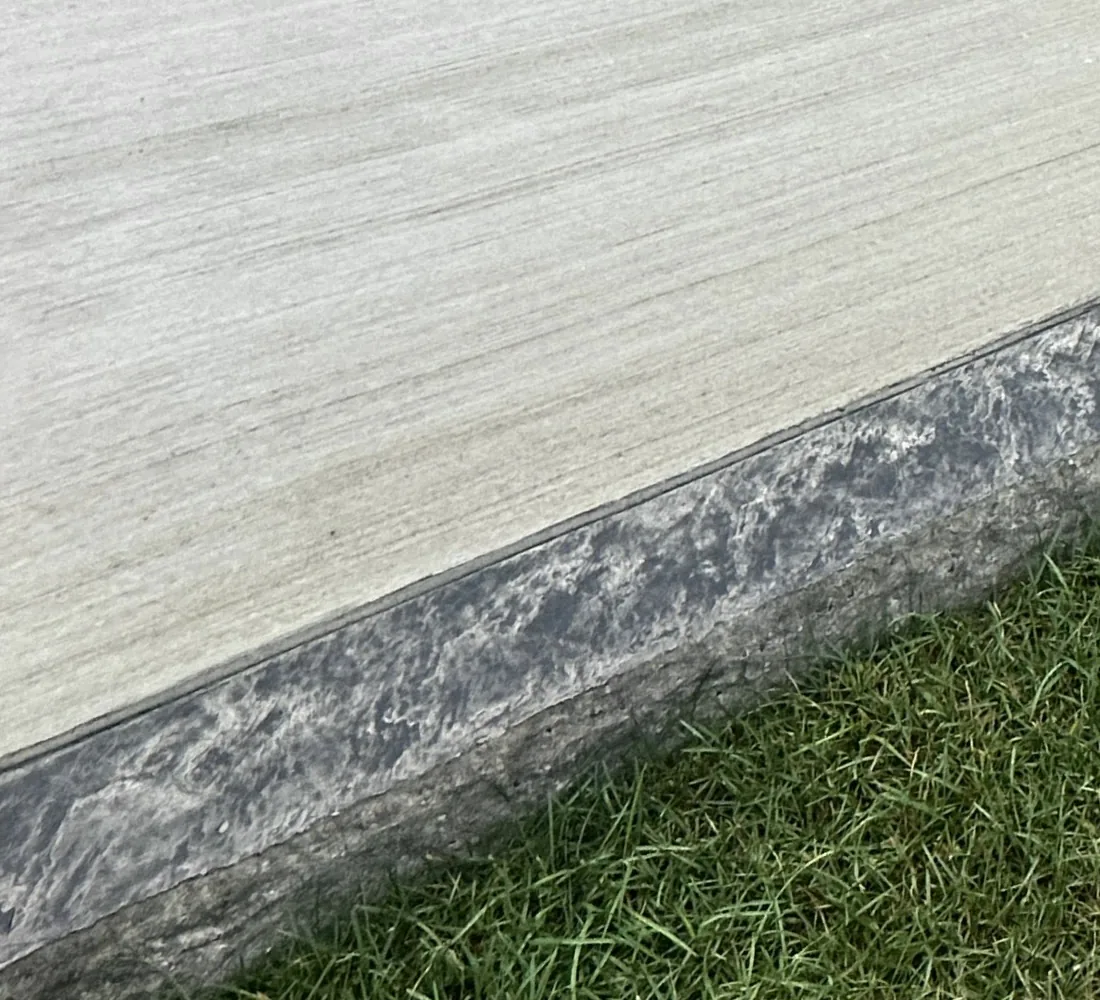 Close view of the textured charcoal border at the patio edge
