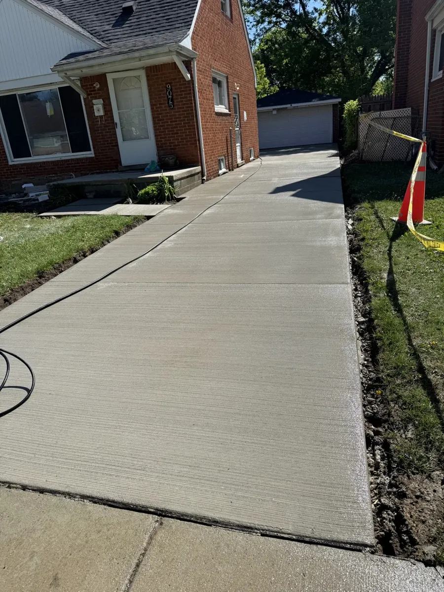 A completed driveway in front of a brick Cape Cod home