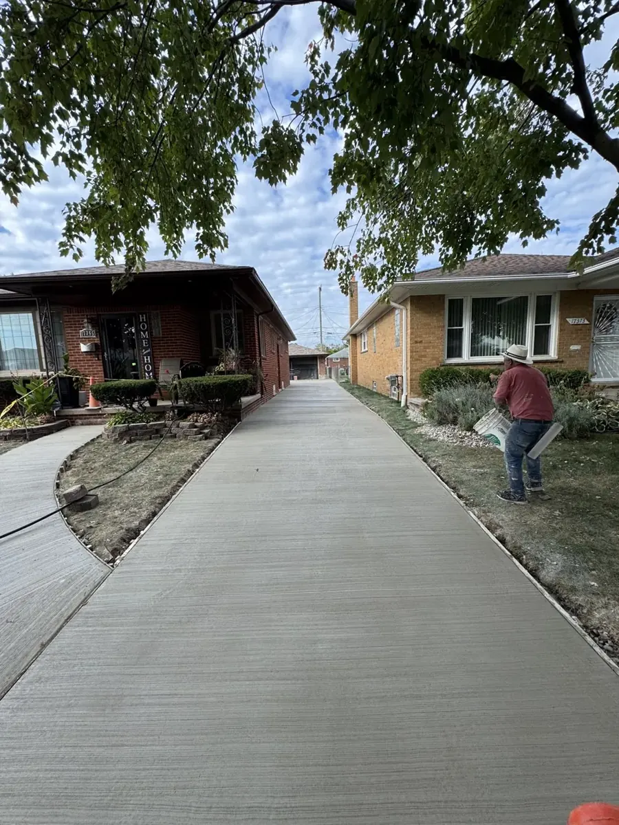 A fresh concrete driveway between two brick homes