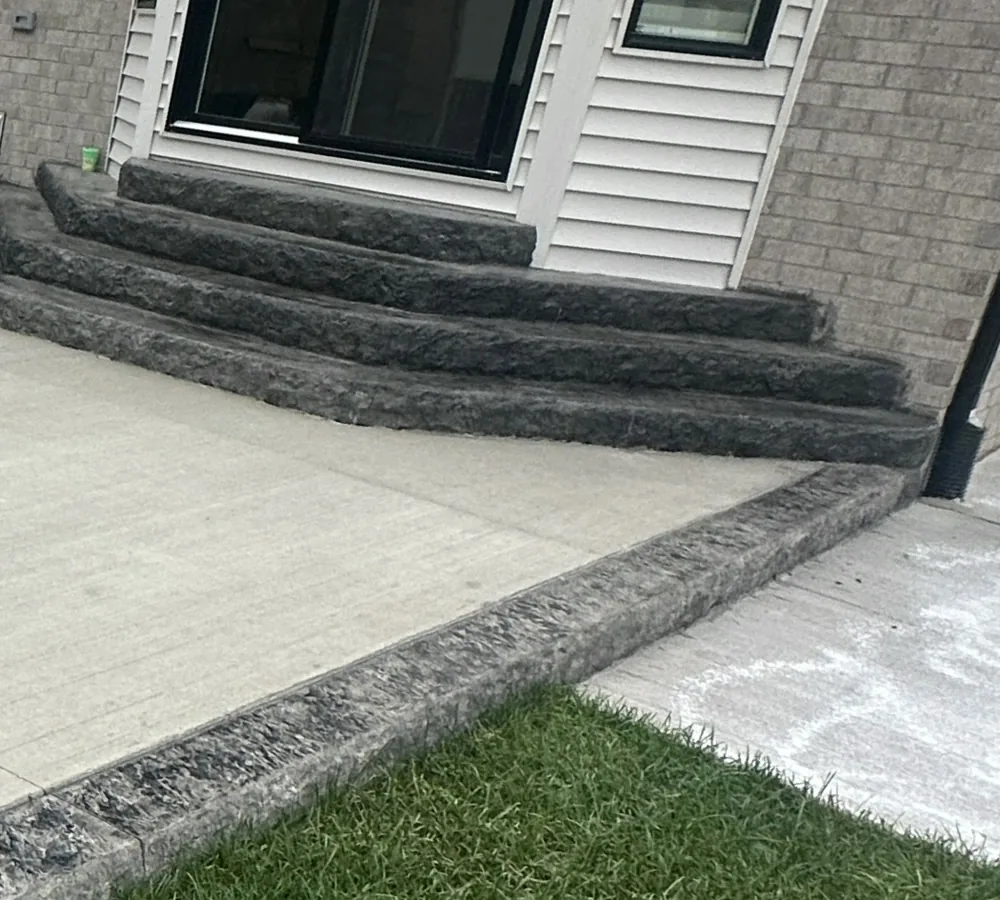 Curved charcoal concrete steps at the patio entrance